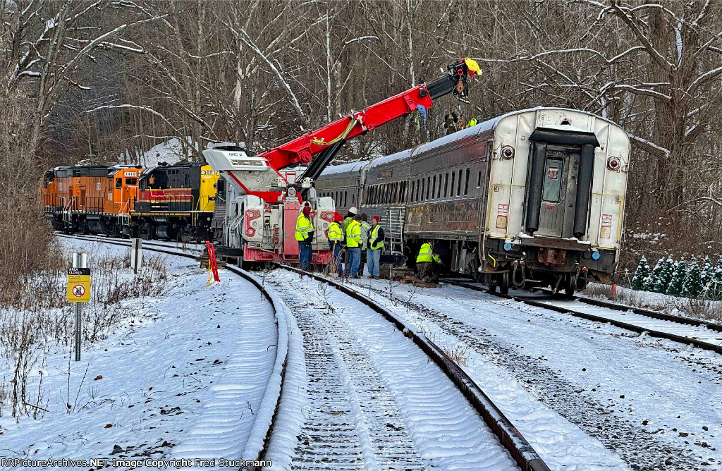 I'm guessing that the coaches are being lifted so that rail can be restored under them?